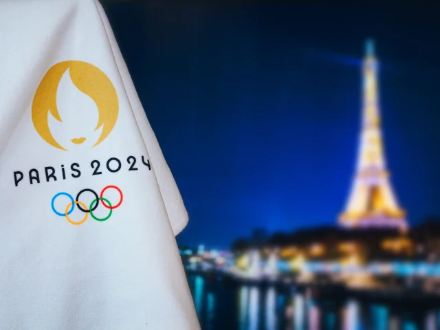 PARIS, FRANCE, AUGUST 8. 2022: Summer olympic game Paris 2024 black background. Official logo of SOG 2024 in Paris on white blanket with dark City in night. Black edit space, sport event